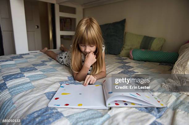 young girl laying on bed reading book - sängerin bildbanksfoton och bilder