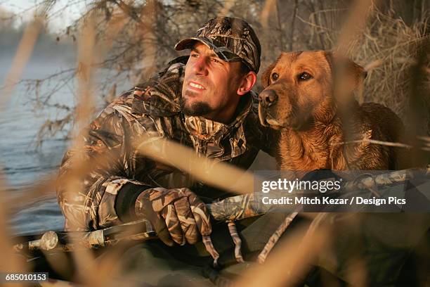 waterfowl hunter in boat with yellow rusty lab - water bird stock pictures, royalty-free photos & images