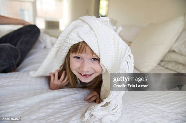 young girl peeking head out from under blanket on bed - sängerin bildbanksfoton och bilder