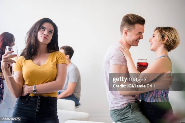 woman at party rolling eyes at affectionate couple - angry boyfriend stock pictures, royalty-free photos & images