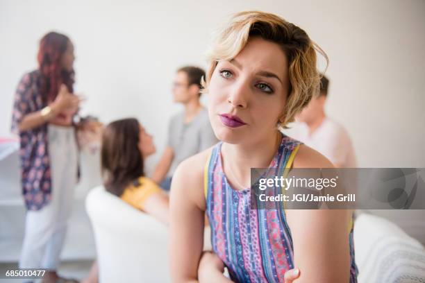 portrait of woman sulking at party - fish out of water photos et images de collection