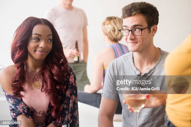 curious couple flirting at party - shy stock pictures, royalty-free photos & images
