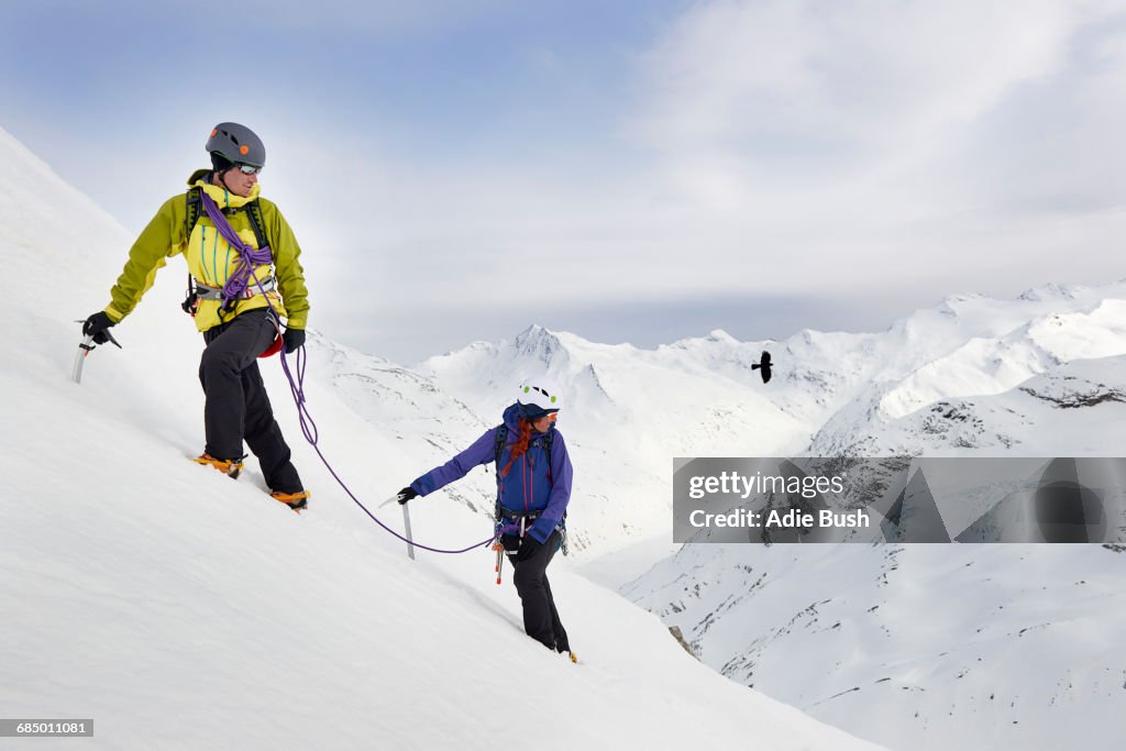 Mountaineers ascending snow-covered mountain, Saas Fee, Switzerland