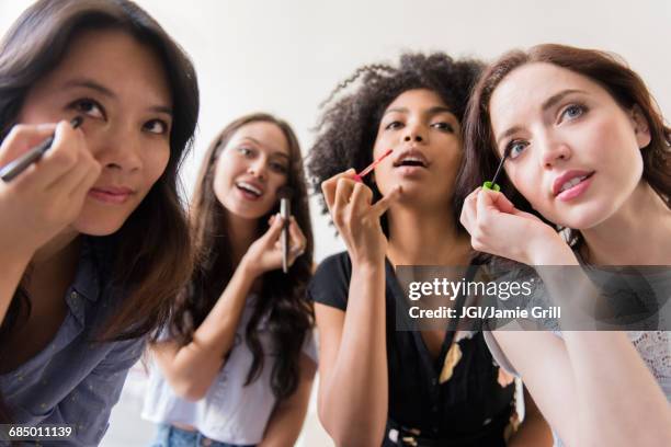 women applying makeup in mirror - friends women makeup stockfoto's en -beelden