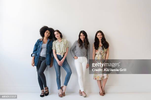 portrait of smiling women leaning on wall - four people stock pictures, royalty-free photos & images