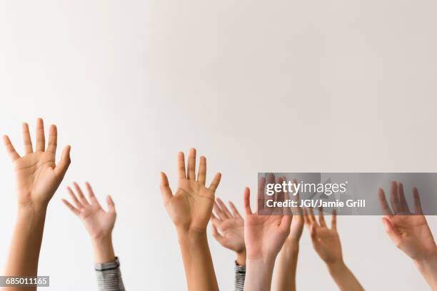 raised hands of women - arms raised photos et images de collection
