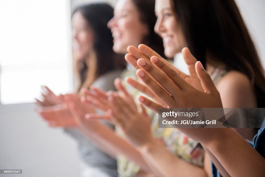 Smiling women applauding