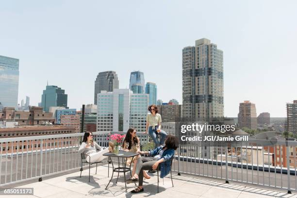 women drinking wine on urban rooftop - jersey city stock pictures, royalty-free photos & images