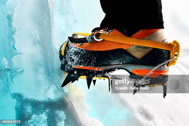 cropped view of ice climbers feet wearing crampons - eisklettern stock-fotos und bilder