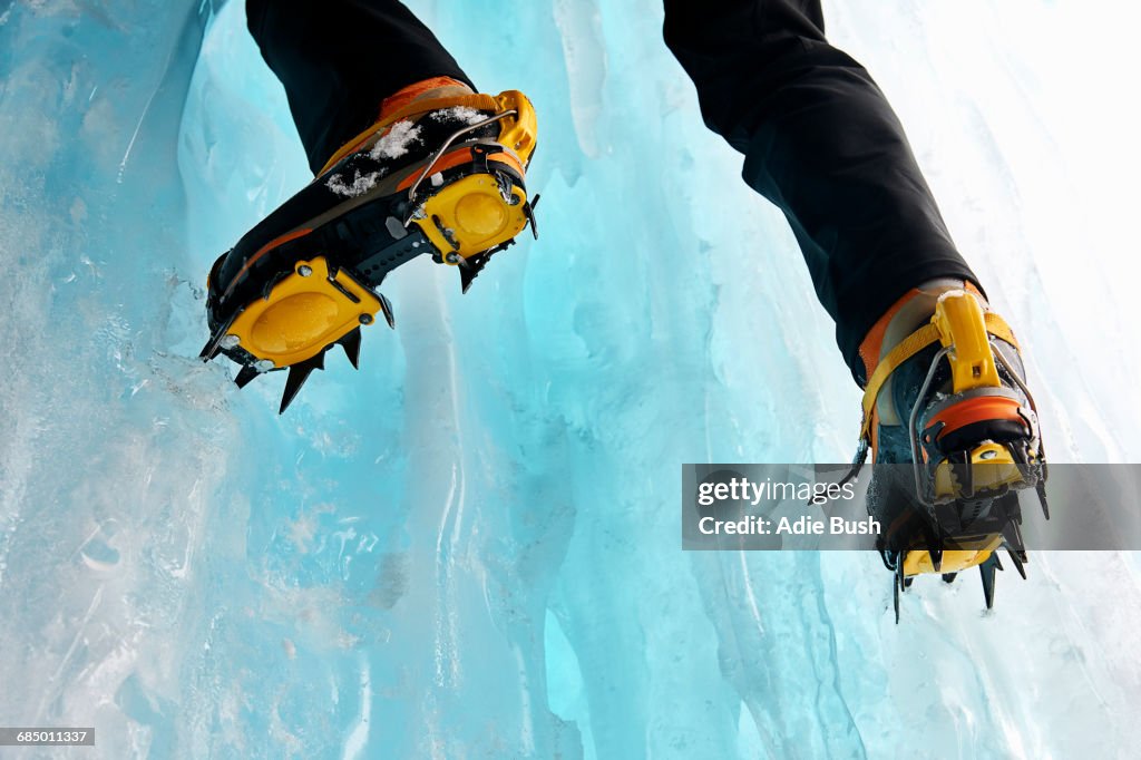 Cropped view of ice climbers feet wearing crampons