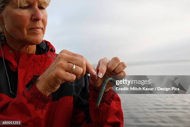 female fishing pro readies her fishing line for smallmouth fishing - fishing hook stock-fotos und bilder