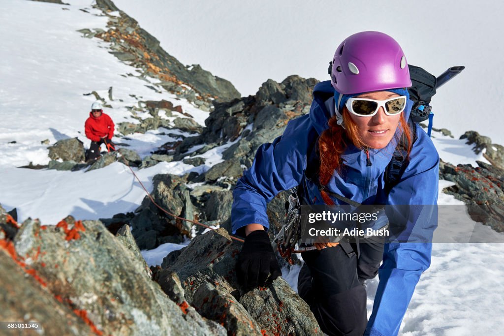 Mountaineer climbing up snow covered mountain, Saas Fee, Switzerland