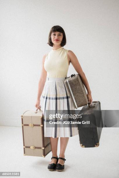 portrait of smiling hispanic woman holding suitcases - carrying luggage stock pictures, royalty-free photos & images