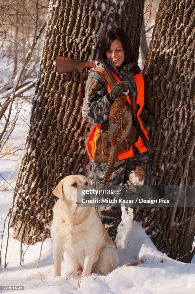 Female Pheasant Hunter In Winter With Yellow Lab