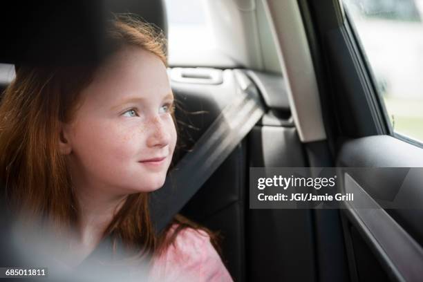 smiling caucasian girl in car looking out window - car grill stock pictures, royalty-free photos & images