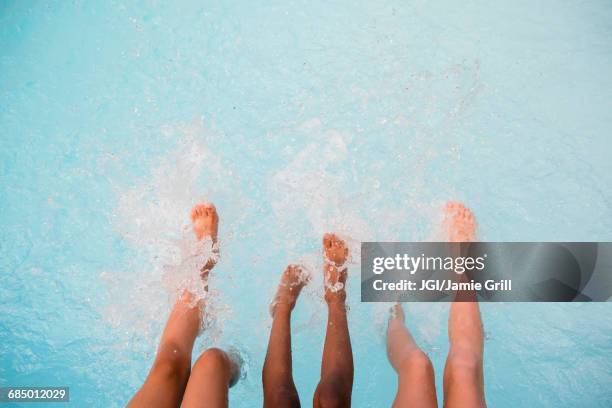 legs of girls splashing feet in swimming pool - feet girl stock pictures, royalty-free photos & images