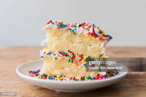 slice of cake with sprinkles on plate - taartpunt stockfoto's en -beelden