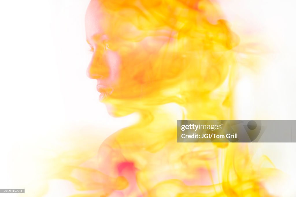 Double exposure of face of Mixed Race woman and fire