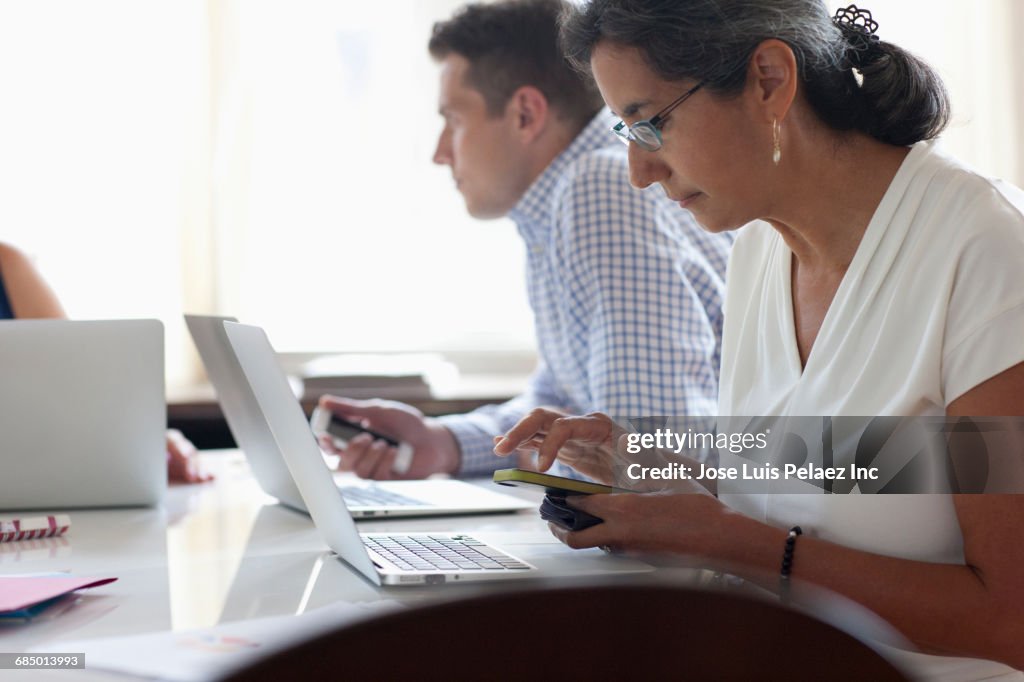 Texting Office Businesswoman Texting On Cell Phone At Desk In Office High-Res Stock ...