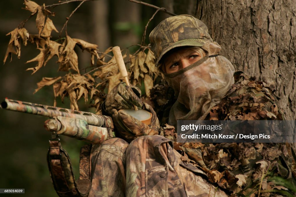 Female Turkey Hunter With Shotgun In A Turkey Blind