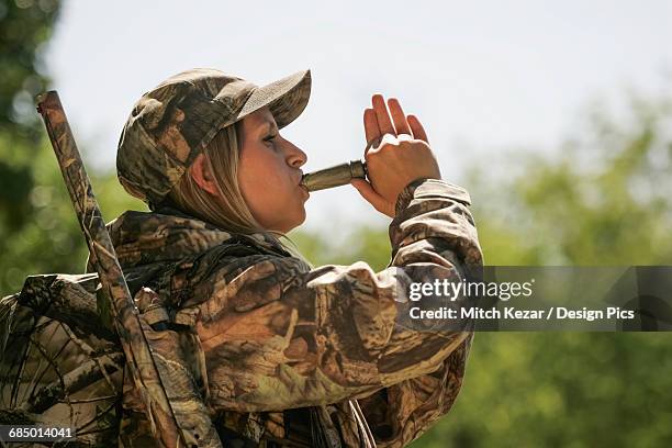 female turkey hunter calling turkey with a turkey call - turkey hunting stock pictures, royalty-free photos & images