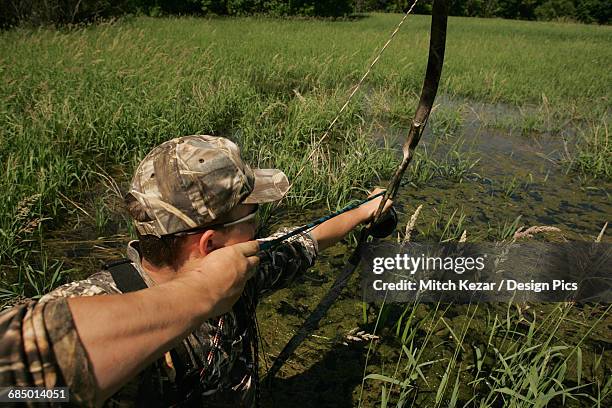 man aims while carp bowfishing - archer fish stock pictures, royalty-free photos & images