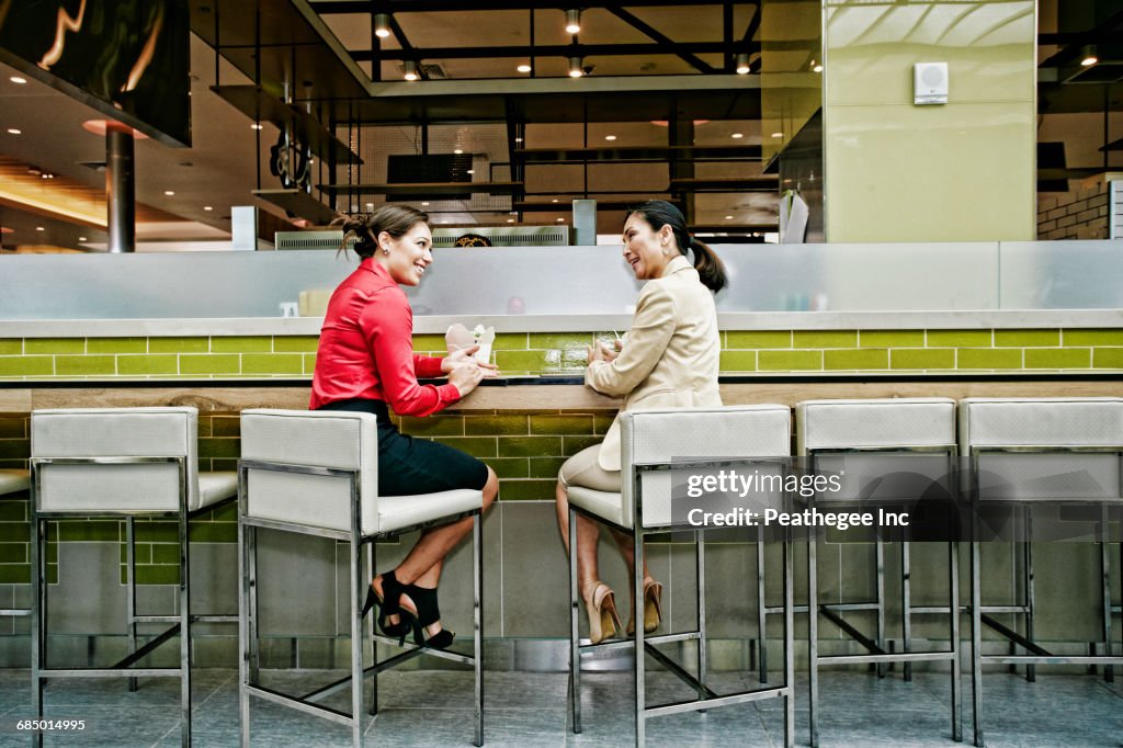 Smiling businesswomen talking in food court