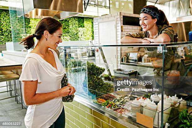 mixed race woman and worker in food court - food court stock pictures, royalty-free photos & images