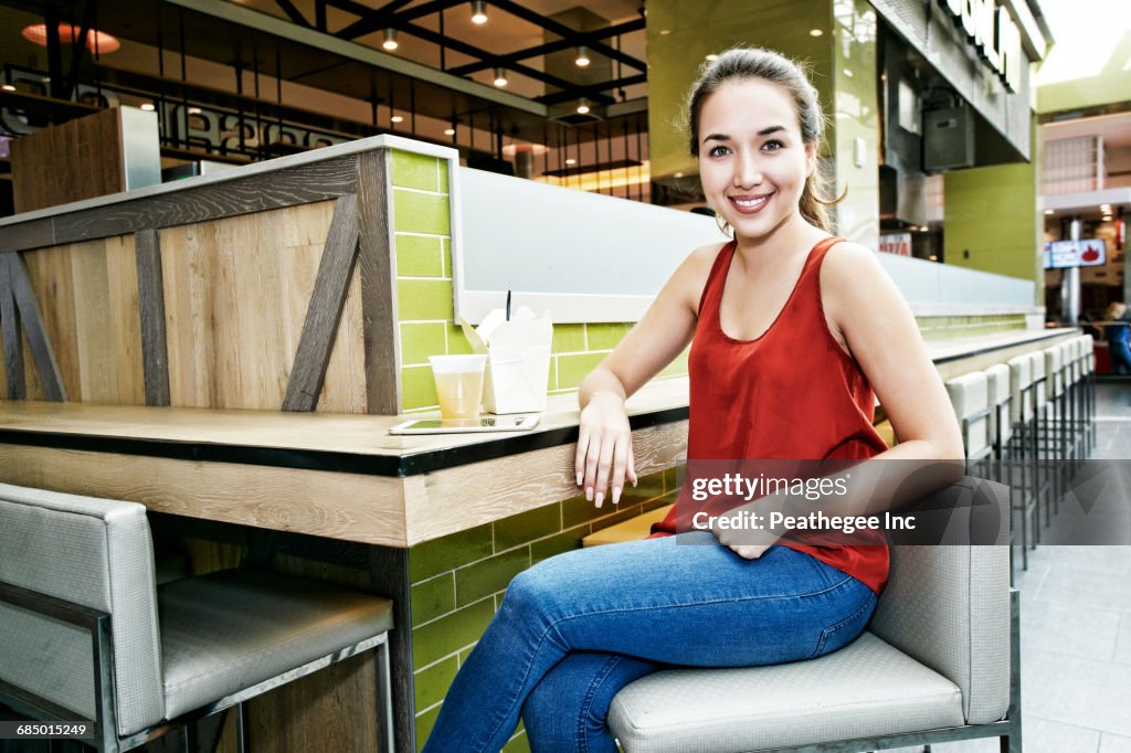 Smiling Mixed Race woman posing in food court