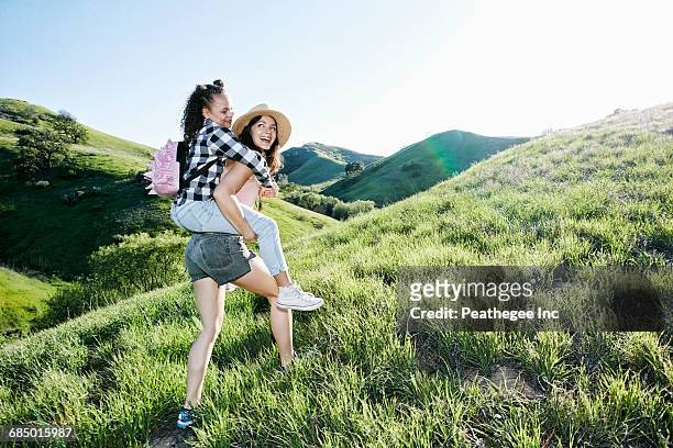 mother carrying daughter piggyback on hill - 13 year old girls in shorts stock pictures, royalty-free photos & images
