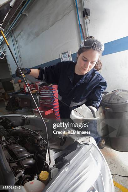 hispanic mechanic checking oil in car engine - dipstick stock pictures, royalty-free photos & images