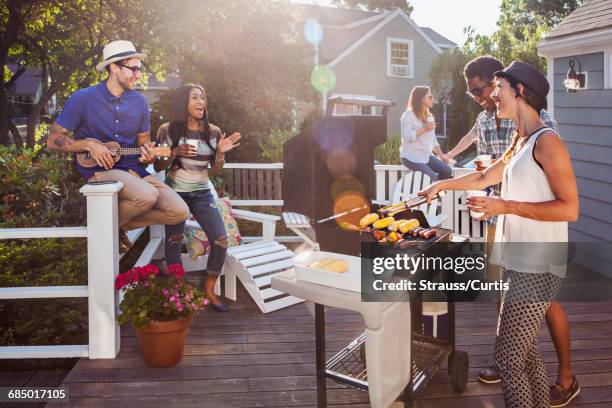 friends enjoying barbecue on patio - patio party foto e immagini stock