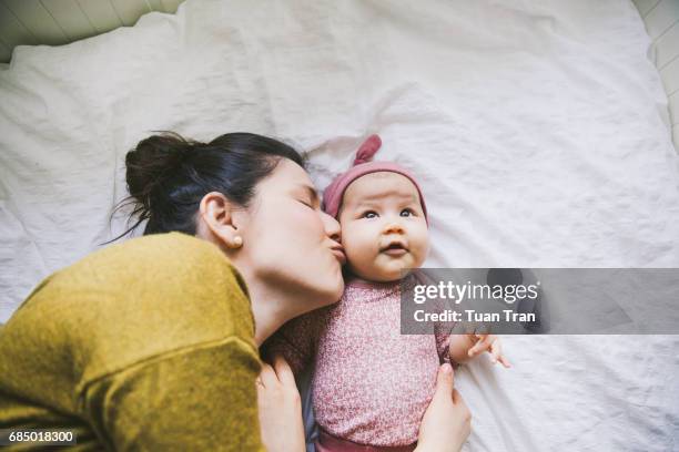 mother kissing baby - portrait baby photos et images de collection