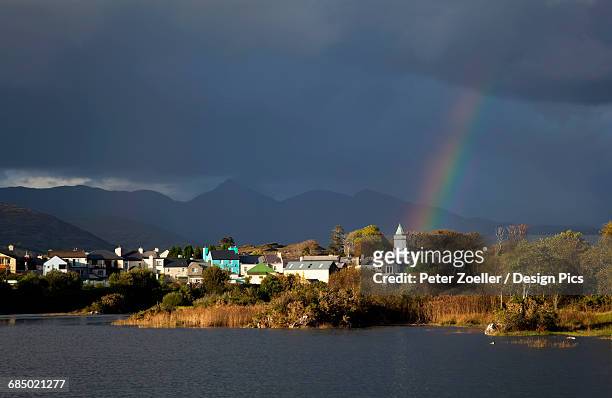 a rainbow shining through the storm clouds over a town - sneem fotografías e imágenes de stock