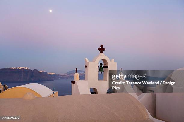 orthodox church with bell and a moon high in the sky at dusk - terence waeland stock-fotos und bilder