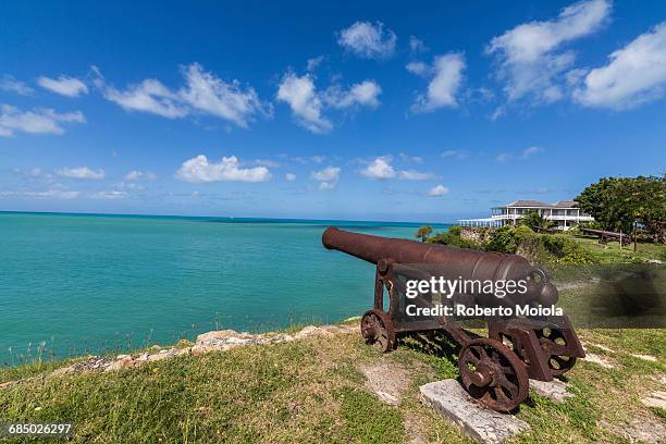 a cannon dating from the 17th century stands guard at fort james one of the most important historical monuments of antigua, leeward islands, west indies, caribbean, central america - antigua leeward islands stockfoto's en -beelden