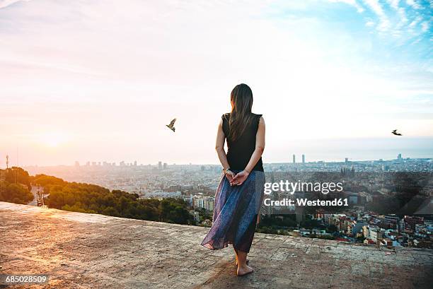 spain, barcelona, woman looking at view over city - uitzichtpunt stockfoto's en -beelden