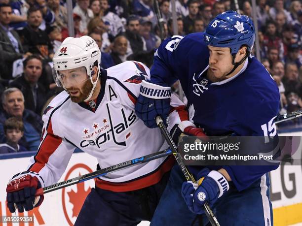 Washington Capitals defenseman Brooks Orpik and Toronto Maple Leafs left wing Matt Martin push off of each other during the third period of Game Six...
