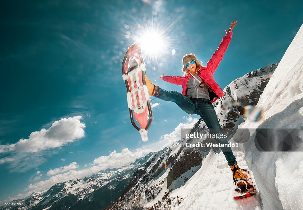 Austria, Salzburg County, Young woman snowshoeing in the mountains