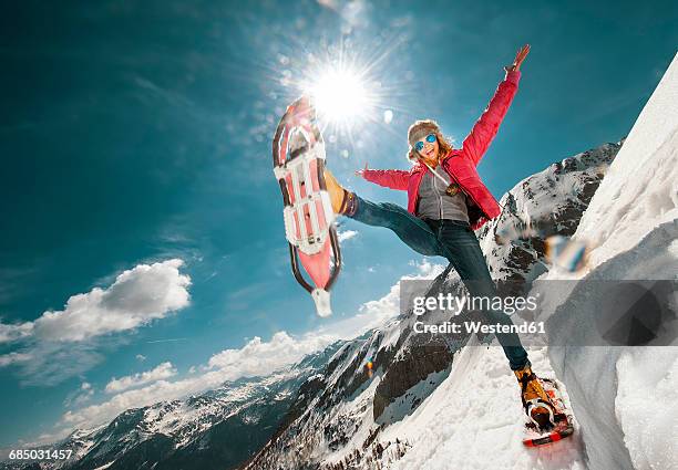 austria, salzburg county, young woman snowshoeing in the mountains - snowshoe stock pictures, royalty-free photos & images
