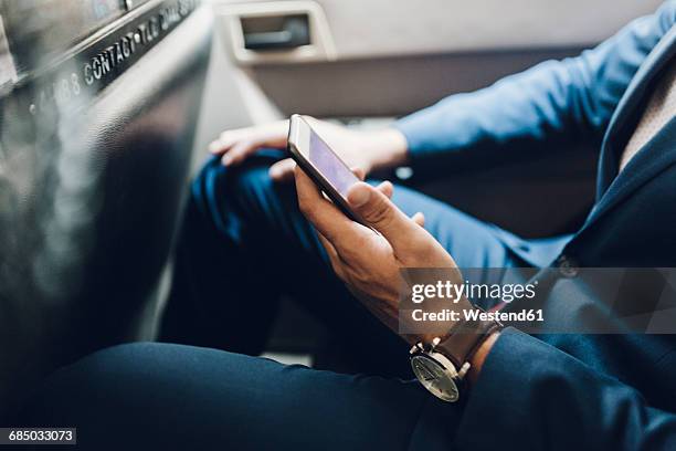 indian businessman using smartphone in taxi - businessman taxi stock-fotos und bilder