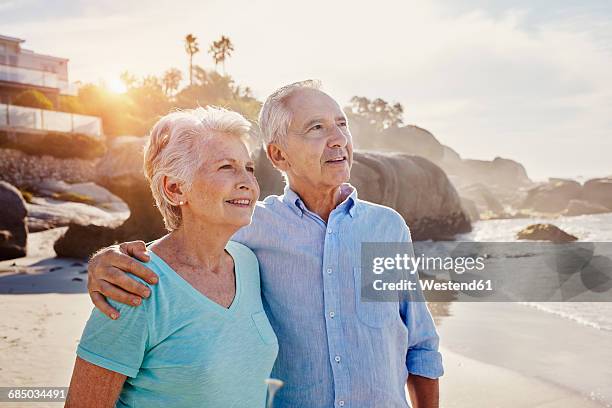 senior couple on the beach - caucasian couple beach stock-fotos und bilder