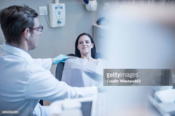 dentist preparing treatment for patient - bib overalls stockfoto's en -beelden