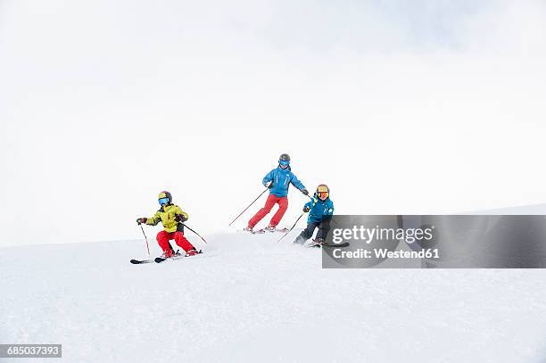 father and two sons skiing together - kid skiing stock pictures, royalty-free photos & images