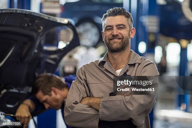 confident car mechanic in repair garage - auto mechaniker stock-fotos und bilder