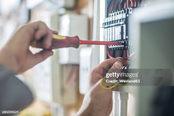 electrician working on wired electrical board - schaltschrank stock-fotos und bilder