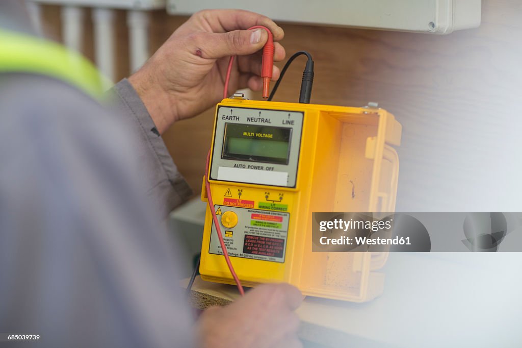 Electrician working with voltmeter