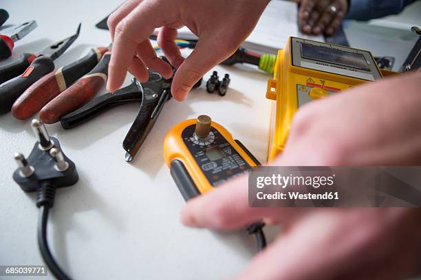 hands and table with electrician tools - voltmeter stock pictures, royalty-free photos & images