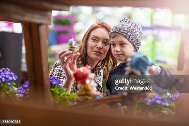 mother and son shopping at garden centre - gartenzwerg stock-fotos und bilder