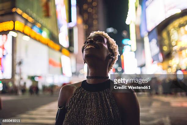 usa, new york city, smiling young woman on times square at night looking up - times square manhattan stock pictures, royalty-free photos & images